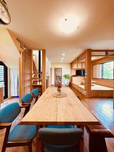 a dining room with a large wooden table and chairs at 小k柯林民宿 最多18人烤肉聚會 親子遊戲區 寵物友善 庭院 電動麻將桌 in Yilan City