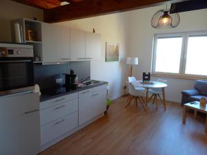 een keuken met witte kasten en een tafel in een kamer bij NEU! Ferienwohnung Junge 4 in Lohe-Rickelshof