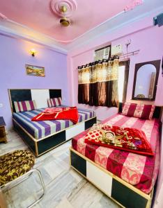 two beds in a room with purple walls at Hotel Best Stay By Hariganga Haridwar in Haridwār