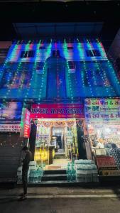 a man standing in front of a building with lights at Hotel Best Stay By Hariganga Haridwar in Haridwār