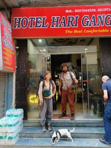 a man and a woman and a dog standing outside a hotel hang gang at Hotel Best Stay By Hariganga Haridwar in Haridwār