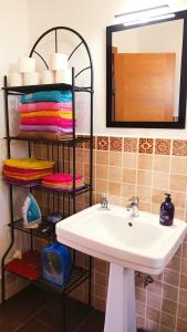 a bathroom with a sink and a mirror and towels at Casa Yahshua in Villaverde