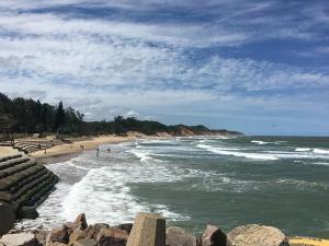 a beach with people walking on the sand and water at Pompano Place Rest in Richards Bay