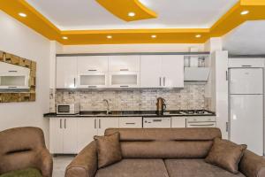 ein Wohnzimmer mit einem Sofa und einer Küche in der Unterkunft Villa Hazal 2 / Kalkan in Kaş