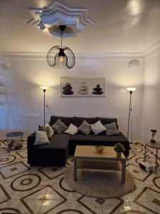 a living room with a black couch and a table at Dar Saphire in Chefchaouen