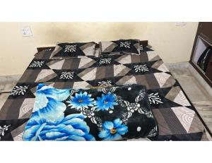 a bed with a quilt with blue flowers on it at Verma Ji Hotel, Raman, Punjab 