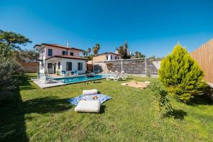 une arrière-cour avec une piscine et une maison dans l'établissement Villa Sazak Duo, à Gelemiş