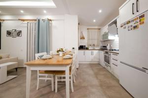 - une cuisine avec une table en bois et des placards blancs dans l'établissement Villa Sazak Duo, à Gelemiş