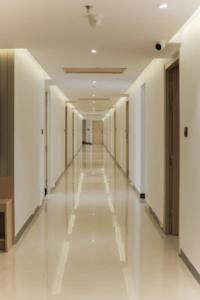 um corredor vazio num edifício com paredes brancas e pisos brancos em MAX PRIME, Madurai em Madurai