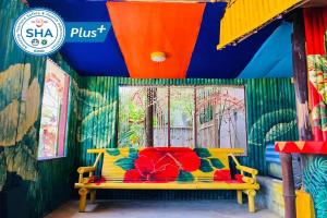 a yellow bench in front of a wall with a mural at Chaba Bungalows in Ban Ai Dao