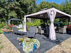 patio z altaną, krzesłami i kwiatami w obiekcie Villa Babette - Ubernachtung, Parkplatz, Kurtaxe, Wifi, Aufraumung - Alles im Preis! w Świnoujściu