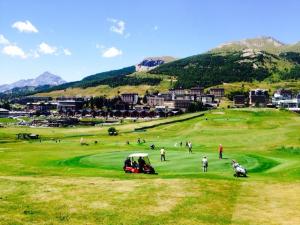a group of people playing golf on a golf course at Cozy mountains apartments in Borgata Sestriere