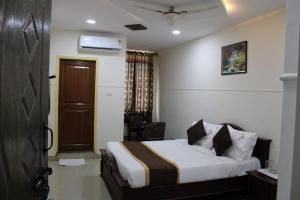 a hotel room with a bed and a door at MALDIVES INN in Bengaluru +4 photos