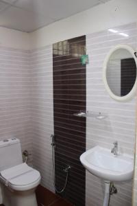 a bathroom with a sink and a toilet and a mirror at MALDIVES INN in Bengaluru