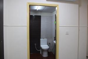a bathroom with a white toilet in a room at MALDIVES INN in Bengaluru