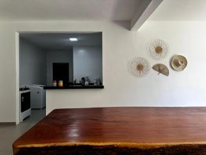 uma sala de estar com uma mesa de madeira e uma cozinha em Casa Barra Grande em Maraú