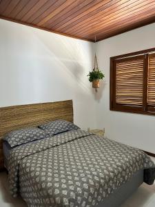 um quarto com uma cama e uma janela em Casa Barra Grande em Maraú