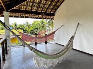 uma rede de descanso num quarto com varanda em Casa Barra Grande em Maraú