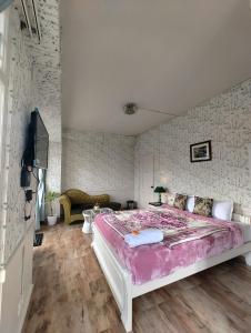a bedroom with a large bed with a pink blanket at The Ark Guest House - Shillong in Shillong