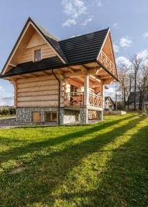a large log cabin with a black roof at Chałpy Pod Ostryszem in Ciche