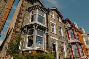 uma antiga casa de tijolos com janelas brancas em Brierholme Guest House em Keswick