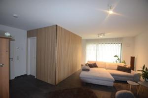 sala de estar con sofá blanco y armario de madera en EG Ferienwohnung Merzig Stadt 60 qm PKW Stellplatz im Innenhof, en Merzig