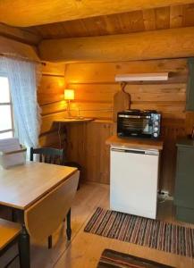 a kitchen with a small refrigerator and a microwave at Stallen - koselig lite hus på gårdstun in Skjåk