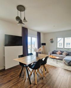 een woonkamer met een tafel en stoelen en een bank bij Villa Eckhart in Göhren