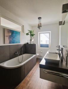 a bathroom with a large tub and a sink at Villa Eckhart in Göhren