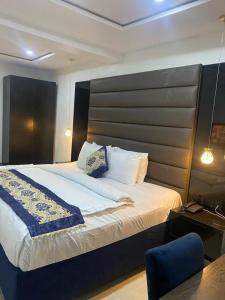 een slaapkamer met een groot bed en een blauwe stoel bij Water Ripples Hotel Lekki in Lekki