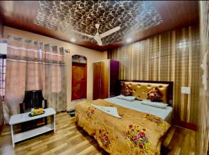 a bedroom with a large bed and a table at The Upscale Inn in Srinagar