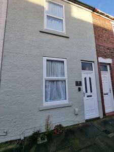 a house with two windows and a white door at Cosy home in York in York