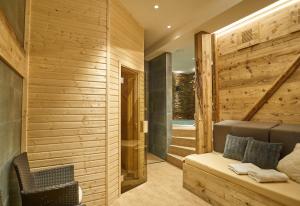 um quarto com paredes de madeira e um banco numa casa em Hotel Toč em Lipová-lázně