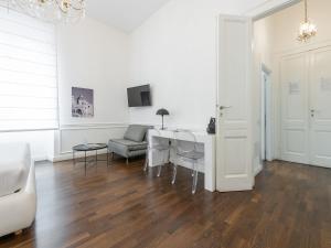 ein weißes Wohnzimmer mit einem Tisch und einem Sofa in der Unterkunft PLEY Cagliari Boutique Rooms in Cagliari