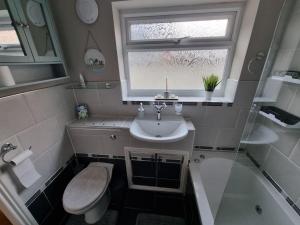 a bathroom with a sink and a toilet and a window at Cosy home in York in York