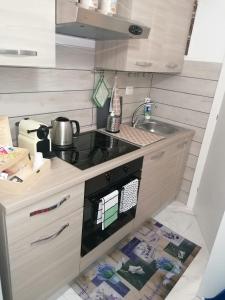 uma pequena cozinha com um fogão e um lavatório em Fiumicino Aeroporto Casa Vacanze Orchidea em Fiumicino
