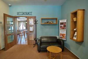 a living room with a leather couch and a table at Hotel Toč in Lipova Lazne