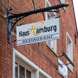 a sign on the side of a brick building at Restaurant Haus Hamburg in Leer