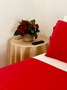 una mesa con un jarrón de flores junto a una cama en Mets en Athens