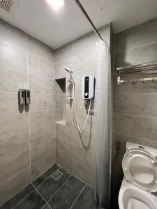 uma casa de banho com um chuveiro e um WC. em Roxy Sematan Beach Townhouse Deluxe 7 ,8 ,9 em Sematan