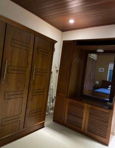 Un dormitorio con un gran armario de madera y un espejo. en Home by the river, en Bollegala