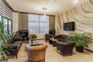 a lobby with couches and a tv and plants at The Rest Port Hotel in Edirne