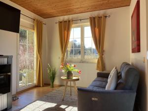 ein Wohnzimmer mit einem blauen Sofa und einem Tisch in der Unterkunft Ferienhaus Wild Schlögl in Leutschach
