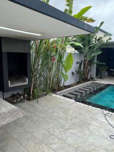 un patio trasero con chimenea y piscina en VILLA AVA, en Entre-Deux