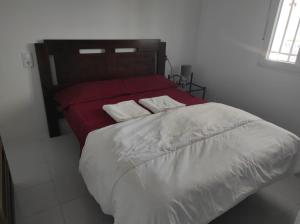 un letto con due cuscini sopra in una camera da letto di Casa Rural con Piscina Verdugo a El Puerto de Santa María Altre 25 foto