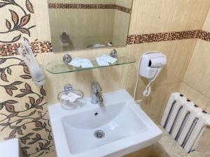 a bathroom sink with a glass shelf above it at Belon inn in Astana