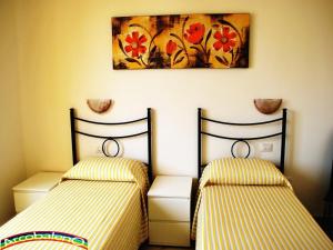 2 Betten in einem Zimmer mit Wandgemälde in der Unterkunft Il Nuovo Arcobaleno in Alghero