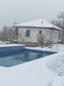 una casa ricoperta di neve con piscina di Apartman Petrovic a Rudnik