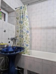 a bathroom with a blue sink and a bath tub at Buddha Hostel in Chişinău