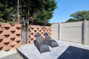 2 chaises assises sur une terrasse à côté d'une clôture dans l'établissement Huis voor 8 personen - NACHT 23, à La Panne